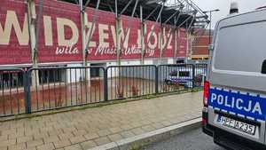 Radiowóz policyjny stoi przed stadionem.