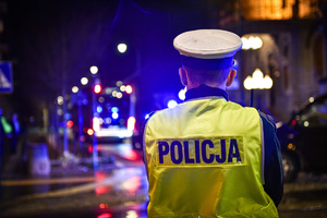 Policjant na tle miasta nocną porą.