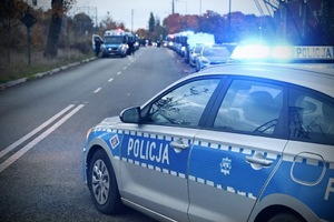 Radiowóz policyjny na tle stadionu.