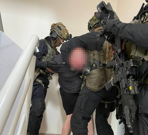 Policjanci z Samodzielnego Pododdziału Kontrterrorystycznego Policji w Krakowie prowadzą zatrzymanego mężczyznę.