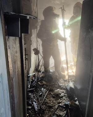 Strażacy sprawdzają pomieszczenie po pożarze.