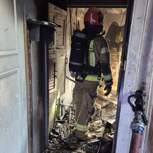 Strażak w pomieszczeniu po pożarze.