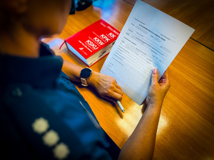 Policjantka trzyma protokół w ręce.