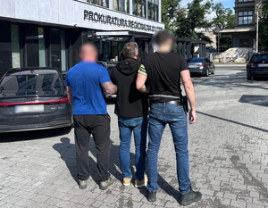 Policjanci z zatrzymanym mężczyzną przed Prokuraturą Regionalną w Łodzi.