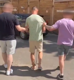 Policjanci prowadzą podejrzanego.