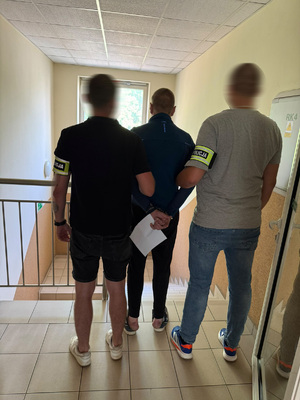 Policjanci prowadzą zatrzymanego.