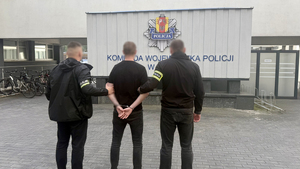 Policjanci trzymają zatrzymanego.
