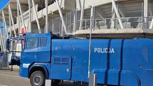 Policyjna armatka wodna na tle stadionu.