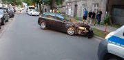 Na jezdni stoja rozbite samochody w tym czarny sprawcy oraz oznakowany radiowóz policyjny