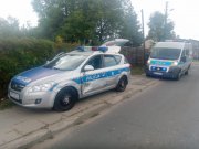 Rozbity oznakowany radiowóz i stojący za nim radiowóz policjantów ruchu drogowego