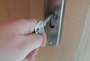 zdjęcie przedstawia klucz pasowany do zamka w drzwiach