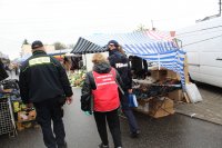 Policja, Straż Miejska i pracownik Powiatowej Stacji Sanitarno-Epidemiologicznej w Skierniewicach kontrolują targowisko miejskie, przechodzą pomiędzy straganami