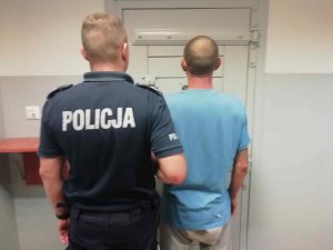 Mężczyzna i policjant widziani z tyłu