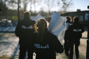 Policjanci niosący karmę dla schroniska.