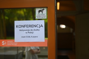 Kartka umieszczona na drzwiach wejściowych uczelni z nazwą konferencji,