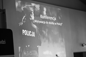 Slajd rozpoczynający konferencję, policjant stojący tyłem a obok temat konferencji.