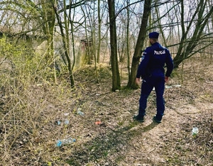 Policjant patrolujący las.
