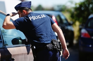 Policjant sprawdzający czy wewnątrz nie ma pozostawionych dzieci lub zwierząt.