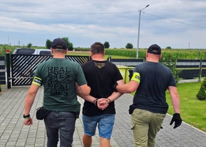 Policjanci doprowadzający zatrzymanego.