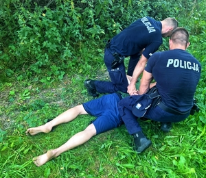 Policjanci zatrzymujący sprawcę zdarzenia drogowego.