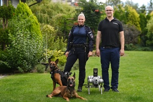 Edyta Mądrzycka i Janusz Będkowski oraz dwa psy policjantki, a obok robo-pies stworzony przez Janusza.