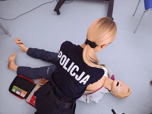Policjantka podczas szkolenia z reanimacji osoby poszkodowanej.