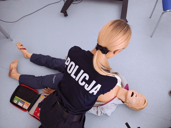 Policjantka podczas szkolenia z reanimacji osoby poszkodowanej.