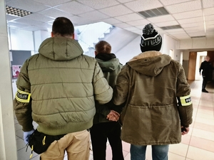 Policjanci kryminalni z zatrzymanym w trakcie doprowadzenia.