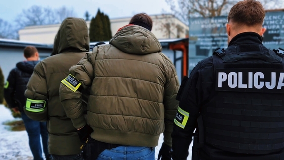 Policjanci i Strażnicy Graniczny wchodzący na teren hotelu celem kontroli legalności mieszkających tam mieszkańców.