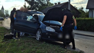 Policjanci przeszukujący pojazd.