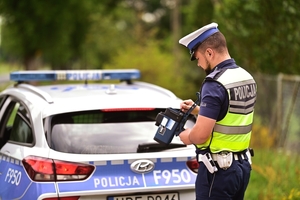 Policjant przy radiowozie.
