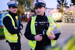 Policjanci rozdający odblaski.