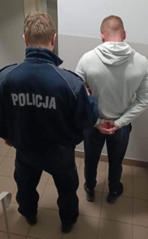 Mężczyzna i policjant stojący tyłem.