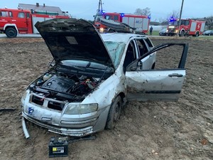 Na polu rozbite auto osobowe, na drodze 3 radiowozy oznakowane strażackie.