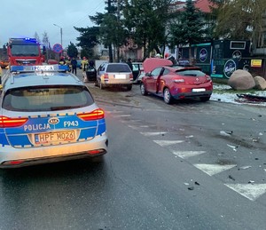 na ulicy stoi oznakowany radiowóz, wóz strażacki obok dwa samochody osobwe