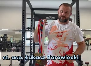 st. asp. Łukasz Borowiecki z medalami w dłoni.