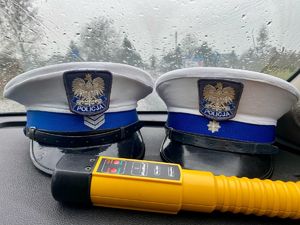Zdjęcie przedstawiające dwie czapki policjantów ruchu drogowego oraz alkosensor.