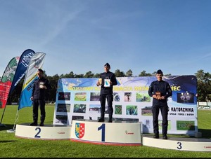 Zawodnicy w mundurach na podium.