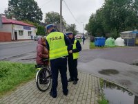 policjanci z Wydziału Ruchu Drogowego przekazują odblaskową kamizelkę rowerzystce