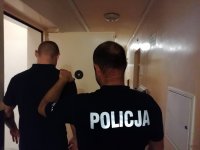 policjant osadza zatrzymanego w policyjnym areszcie
