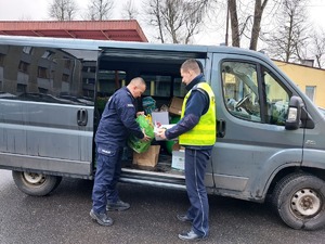 Policjanci wkładają paczki do busa.