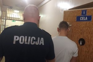 Policjant z zatrzymanym mężczyzną.