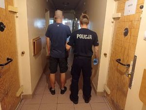 Policjant z zatrzymanym sprawcą kradzieży elementów rusztowania.