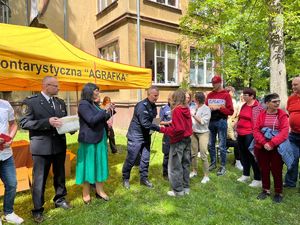 Komendant Powiatowy Policji w Pabianicach wręcza uczestnikowi pamiątkowy dyplom, obok stoją partnerzy gry miejskiej.
