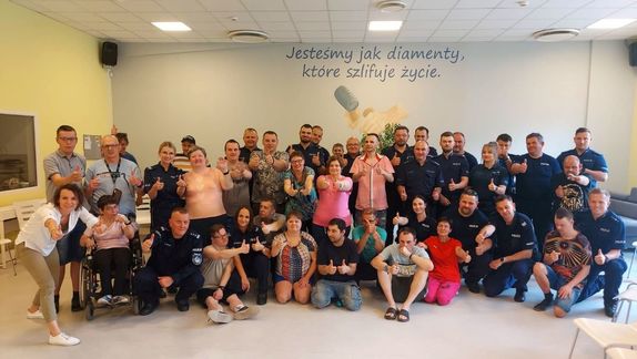 Grupowe zdjęcie na który widać uczestników Warsztatu Terapii Zajęciowej i policjantów uczestniczących w szkoleniu.