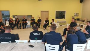 Policjanci uczestniczą w szkoleniu, wszyscy siedzą w okręgu.