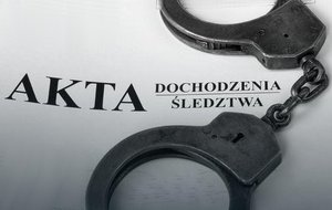 Kajdanki leżące na aktach sprawy.