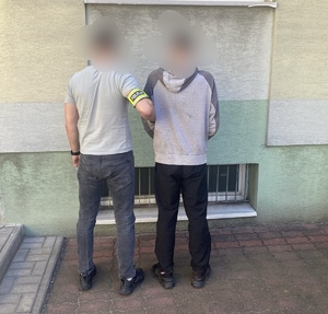 nieumundurowany policjant trzyma zatrzymanego mężczyznę