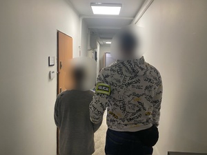 nieumundurowany policjant trzyma zatrzymanego mężczyznę