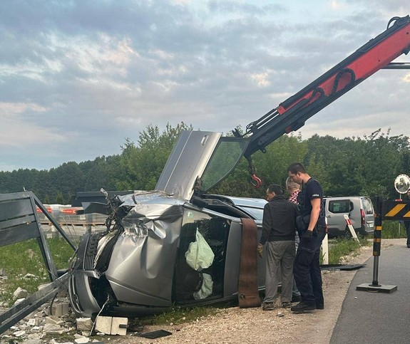 Auto biorące udział w zdarzeniu. Przy pojeździe stoi policjant i mężczyzna wykonujący jego holowanie.